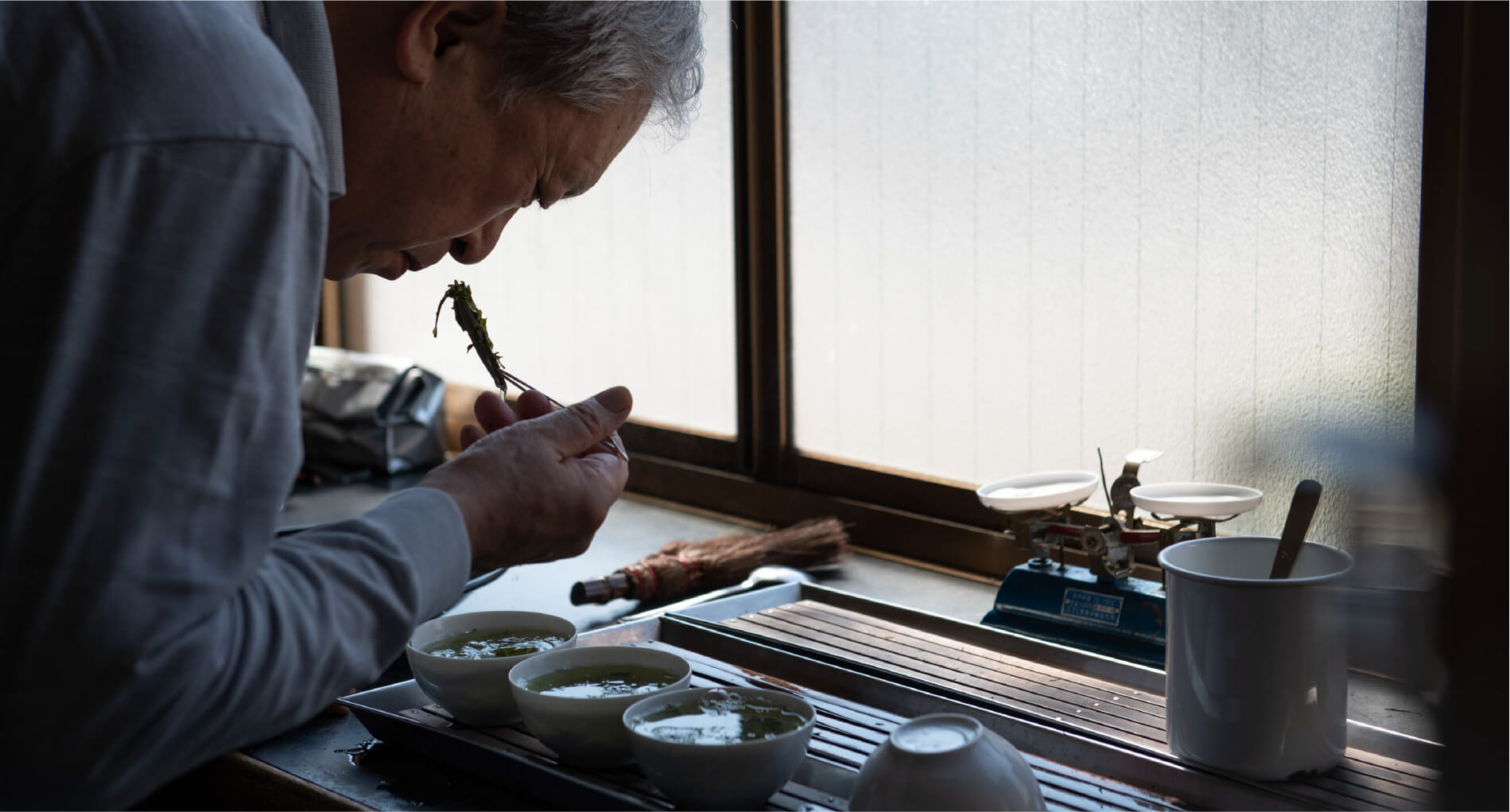 職人がお茶の葉の匂いを嗅いでいる写真