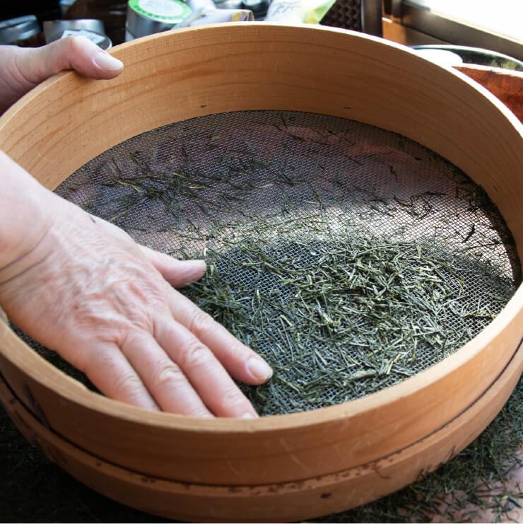 手で触って茶葉をふるいわけしている写真
